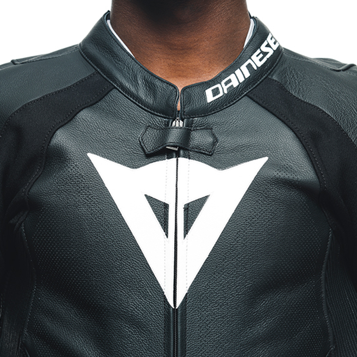 DAINESE TOSA 1 PCS LEATHER SUIT PERF. 胸口拉鍊與DAINESE三角標誌特寫，可見打孔透氣設計與領口彈性構造