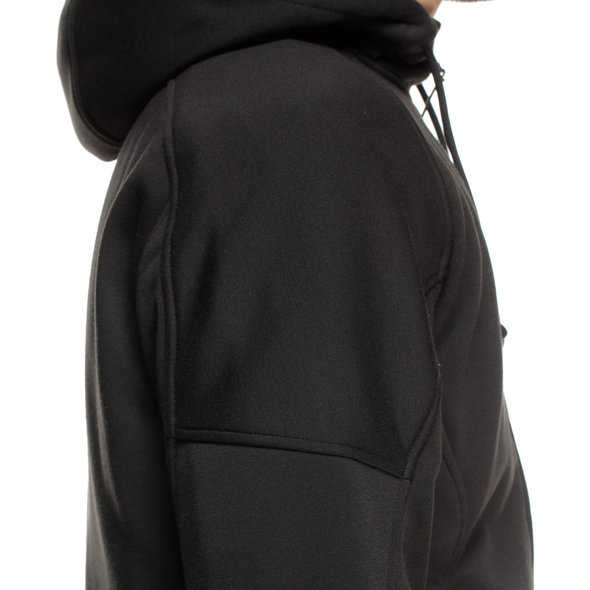 DAINESE BOVISA SAFETY HOODIE FULL ZIP 下擺口袋拉鍊特寫，模特兒以手指拉開下擺隱藏口袋，可見DAINESE三角品牌吊牌與羅紋下擺收邊，展示內側防水口袋設計細節，義大利原廠刷毛連帽防摔衣