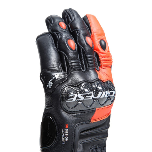DAINESE CARBON 4 SHORT LEATHER GLOVES 黑螢光紅配色手套掌心朝上展示，手指內側可見黑色皮革搭配橘紅色指節插件，掌心及手背碳纖維護具上DAINESE白色標誌清晰可見，短手套正面照