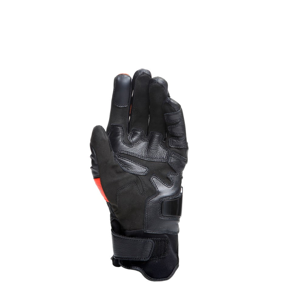 DAINESE CARBON 4 SHORT LEATHER GLOVES 單手手背正面照，可見黑色網布透氣insert與手腕束口帶，手背中央碳纖維複合材料指節護具清晰可見，黑紅配色競技短手套完整展示