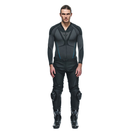 DAINESE DELTA 3 PERF.LEATHER PANTS 黑黑白配色正面照，男性模特兒穿著同系列連身緊身內搭衣與打孔皮褲站立展示，可見膝蓋護具立體輪廓與腰際魔鬼氈束帶，義大利原廠Tutu小牛皮革局部打孔製賽道皮褲