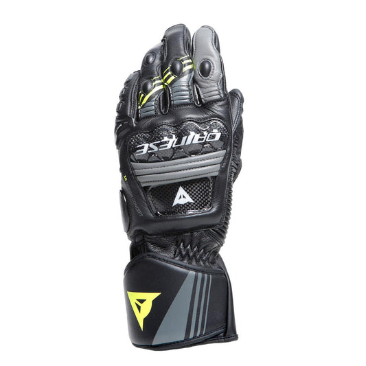 DAINESE DRUID 4 LEATHER GLOVES 黑灰黃配色手套手背正面展示，指節間可見螢光黃拼接與炭灰色線條，碳纖維護具與鏡射DAINESE字樣清晰可見，競技型長手套正面完整照
