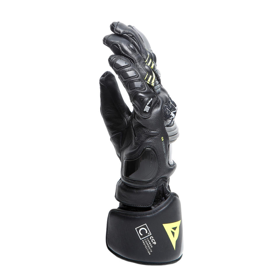 DAINESE DRUID 4 LEATHER GLOVES 袖口特寫，展示CCP碳纖維複合防護標誌與強化預塑形袖口，炭灰色線條裝飾於袖口處清晰可見，黑灰黃配色競技長手套袖口細節照