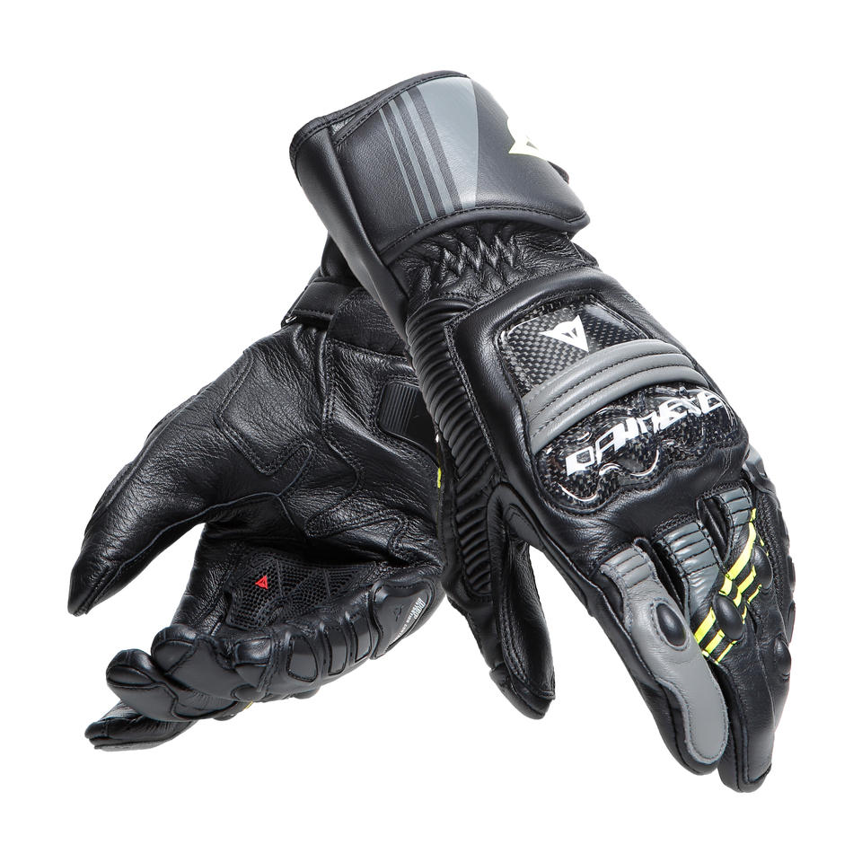 DAINESE DRUID 4 LEATHER GLOVES 一雙手套交疊展示，可見螢光黃拼接與碳纖維護具，山羊皮革縫製質感搭配炭灰色線條裝飾，黑灰黃配色競技型長手套成對陳列照