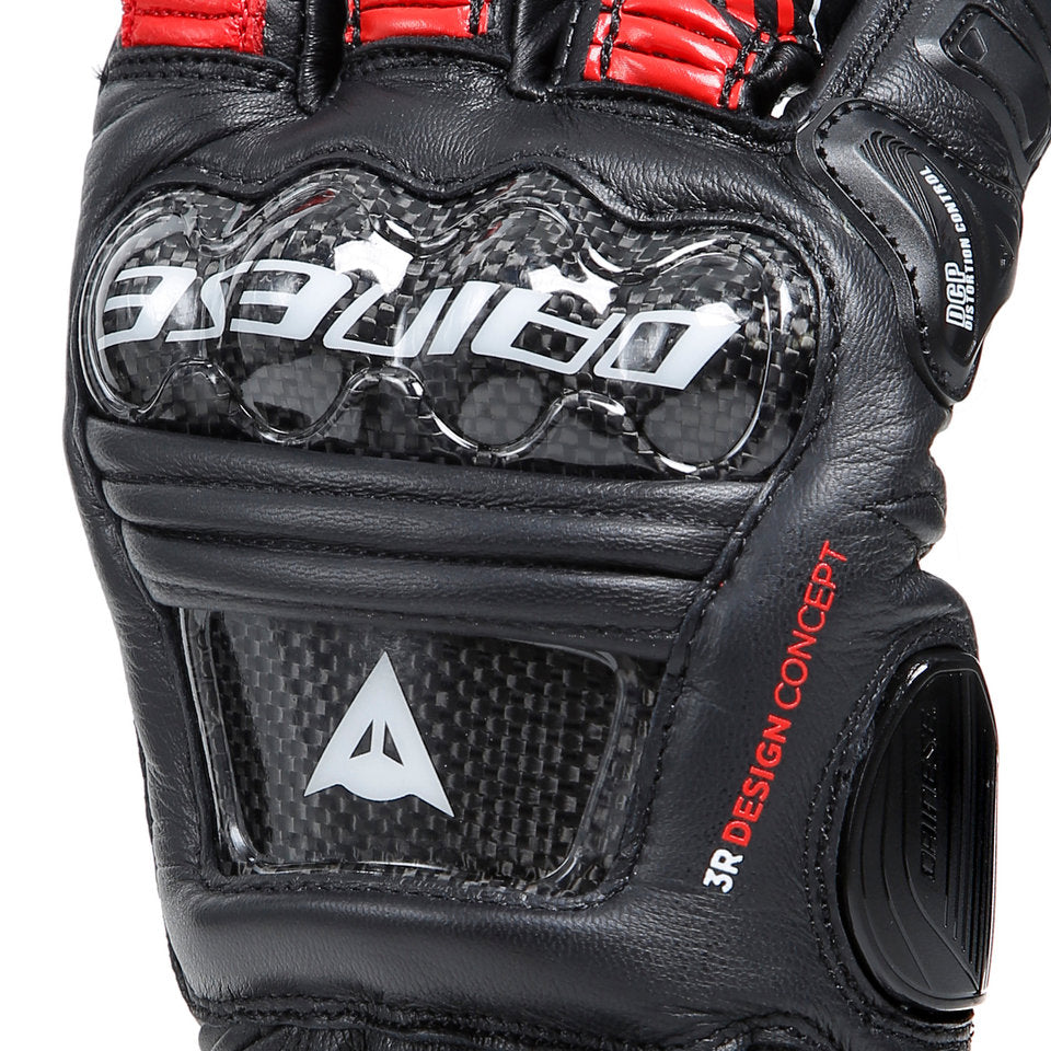 DAINESE DRUID 4 LEATHER GLOVES 指節護具特寫，可見碳纖維複合材料護具紋理與DCP小指防護系統標示，白色DAINESE字樣壓印其上，黑熔岩紅白配色長手套局部細節照