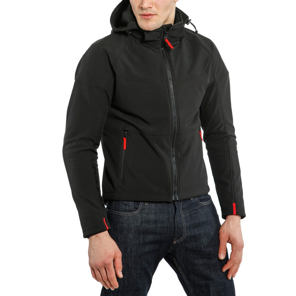 DAINESE IGNITE TEX JACKET 黑/黑配色正面照，男性模特兒戴上連帽並拉起主拉鍊站立展示，可見胸前口袋與袖口紅色拉鍊拉片細節，義大利原廠防風軟殼布料製都會防摔外套，適合城市通勤與日常騎乘穿著