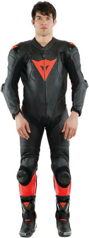 DAINESE LAGUNA SECA 5 1PC PERF. LEATHER SUIT 黑/螢光紅打洞連身賽車皮衣正面實穿照，車手站姿展示完整版型與護具配置，胸口DAINESE三角標誌清晰可見