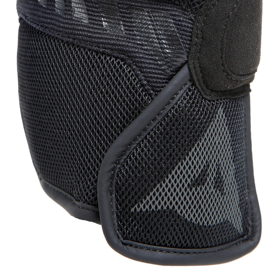 DAINESE MIG 3 UNISEX LEATHER GLOVES 黑色手套腕部特寫，可見透氣網布材質與束口帶車縫細節，灰色品牌標誌壓印於網布上，展現皮革與網布複合結構的透氣防摔手套局部設計